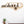 Load image into Gallery viewer, a wooden cutout of a city skyline with a bowl of fruit and a plant on a wooden surface.
